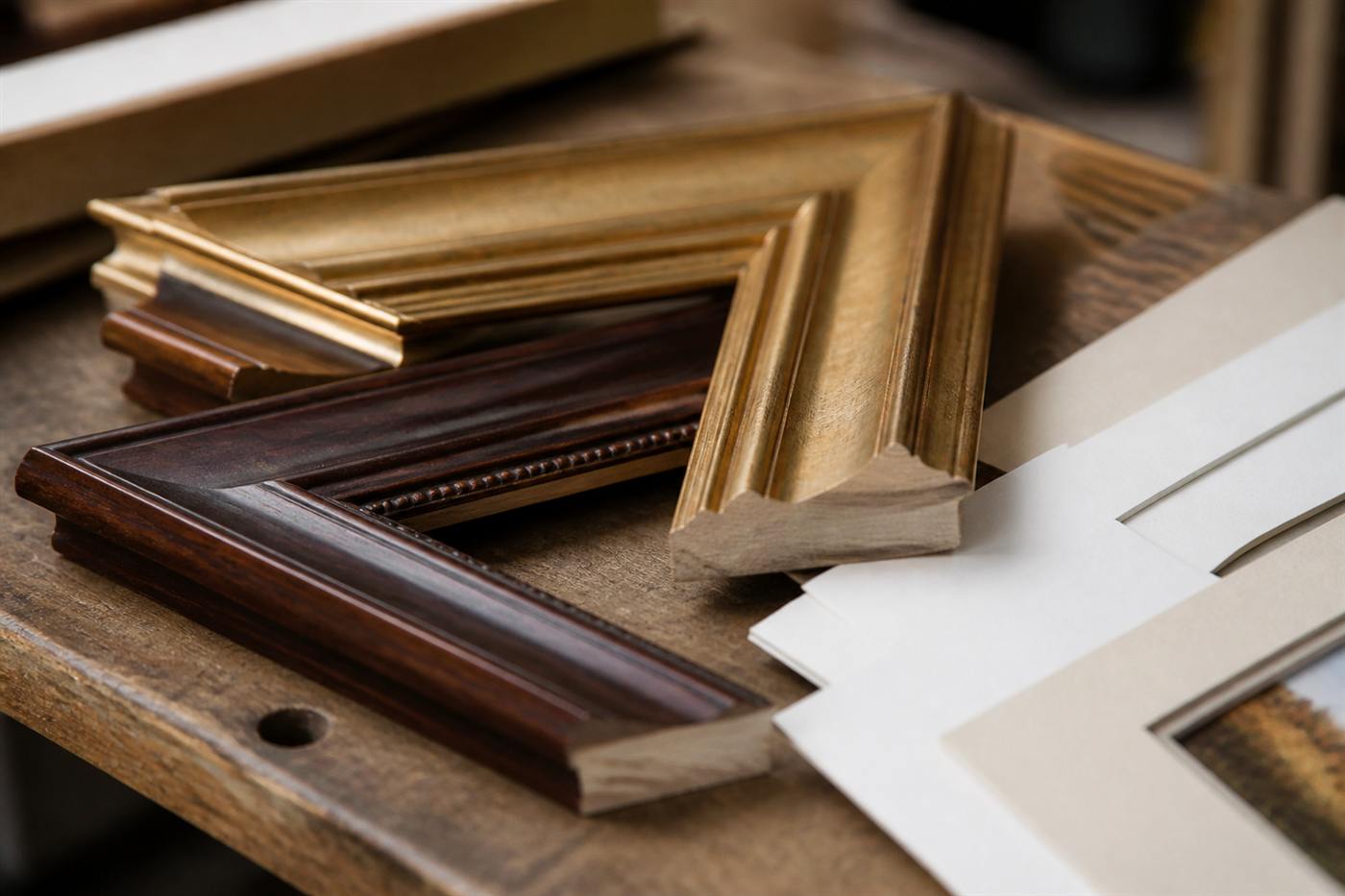 Prints and framing samples on a workshop table